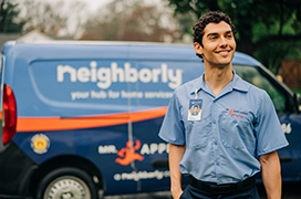 Mr. Appliance service professional smiling in front of branded van.