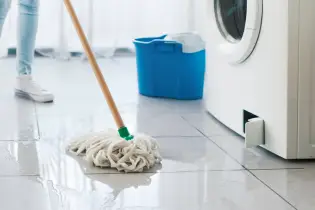 Mopping up water from a leaking washing machine.