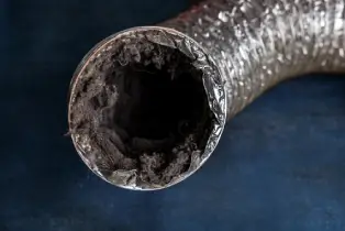 A flexible aluminum dryer vent duct filled with lint, dust and dirt.