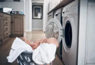 Residential laundry room with clothes dryer and freshly dried laundry.